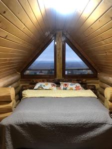 MoldoveneştiCasa din Deal的小木屋内的卧室设有大窗户