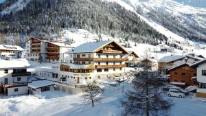 加尔蒂Hotel Valisera的雪中的一个小镇,与山