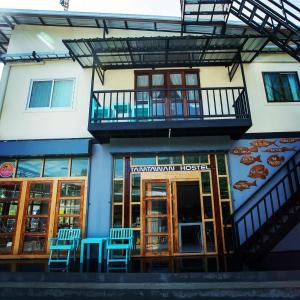 丽贝岛Tamtawan Guesthouse - ตามตะวันเกสเฮ้าส์的建筑前的蓝色椅子酒店