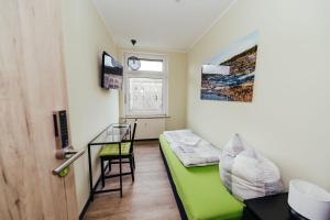 德绍Clubhostel Dessau的小房间设有绿色沙发和窗户