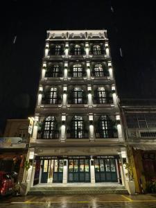 瓜拉丁加奴The Payang Hotel的一座大型建筑,晚上有窗户照明