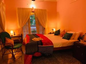 瓦尔卡拉Surendram Villa的一间卧室配有床、椅子和窗户