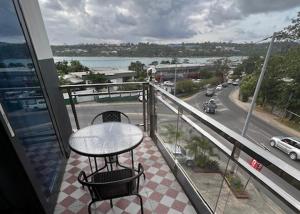 维拉港Crown Royale Hotel & Lounge的阳台配有桌子,享有街道的景色