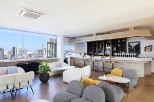 仁川市Hotel The Sea Star的客房设有带白色椅子和桌子的酒吧。