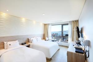 仁川市Hotel The Sea Star的酒店客房配有两张床和一张书桌