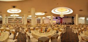 Karaman德莫森酒店的宴会厅配有桌椅和吊灯