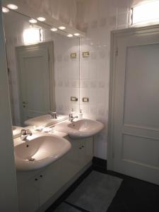 Briosco洛伦佐别墅酒店的白色的浴室设有两个盥洗盆和镜子