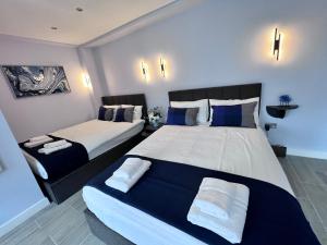 伦敦Hyde Park Studio Flats的一间卧室配有两张带蓝白色枕头的床