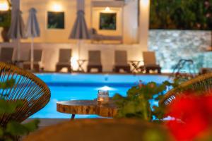 霍里顿Aeolos Hotel & Villas - Pelion的游泳池前的桌椅