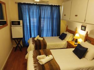 布隆方丹百合旅馆的酒店客房,配有3张带蓝色窗帘的床