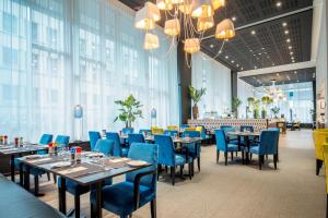 布鲁塞尔欧盟索恩酒店的一间配备有桌子和蓝色椅子的用餐室