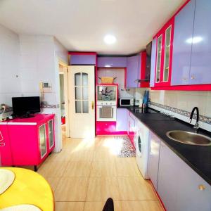 赫塔费Casa grande 14 personas Getafe Madrid的一个带粉红色橱柜和水槽的大厨房