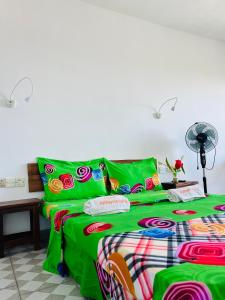贝岛Hôtel Ambatoloaka的一间卧室配有一张带绿色床单的床
