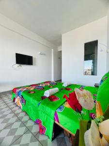贝岛Hôtel Ambatoloaka的一间卧室配有一张带绿色棉被的床