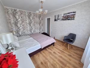 里加Riga City 2 Bedroom Lux Apartments的一间卧室配有一张床、一张桌子和一把椅子