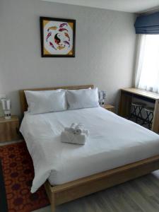 奈扬海滩The Beach Residence by EHM的一张带白色床单的床和两张毛巾
