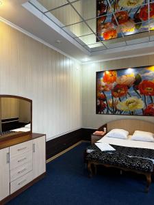 塞米伊Vodnik Hotel的卧室配有一张床,墙上挂有绘画作品