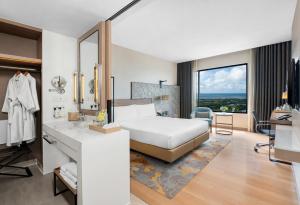 罗勇罗勇市中心假日套房酒店的一间卧室配有床、水槽和镜子