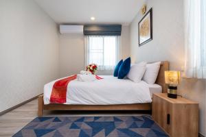 奈扬海滩The Residence @ Naiyang Beach by EHM的卧室设有一张白色大床和一扇窗户。