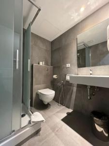 罗马伽德酒店的一间带卫生间、水槽和镜子的浴室