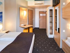 美因茨美因茨酒店-Hbf的配有一张床和一张书桌的酒店客房