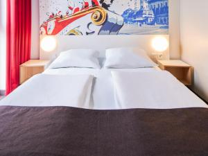 美因茨美因茨酒店-Hbf的一间卧室设有两张床,墙上挂着一幅画