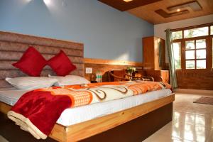 马拉里Guruchhaya hotel and cottages的一间卧室配有一张带红色枕头的大床