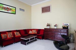 日惹OYO Life 3003 Wisma Handayani Syariah的客厅配有红色的沙发和木制梳妆台