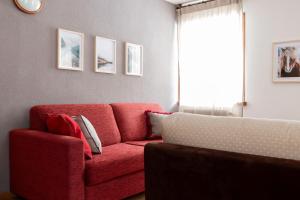 圣卡特琳娜瓦尔夫Chalet Ginepro的客厅设有红色的沙发和窗户。