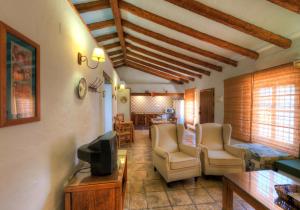科尼尔-德拉弗龙特拉Hacienda los Majadales的客厅配有椅子、电视和桌子