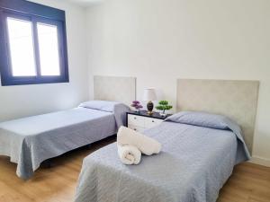 贝纳尔马德纳Sea Views Villa Benalmádena ComoTuCasa的一间卧室配有两张床,上面有一条毛巾