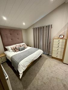 纽基Luxury 3 bedroom Maple View Lodge, Newquay, Cornwall的一间卧室配有一张大床和一个梳妆台