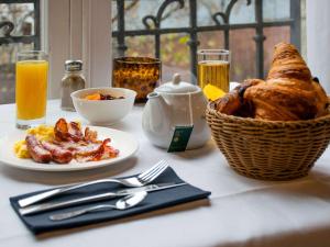 里昂里昂中心皮拉施美居酒店的一张桌子,上面放着一盘食物和一篮面包