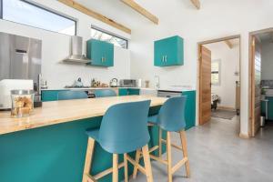 赫曼努斯Mountain and Sea Cottage的厨房配有绿色橱柜和蓝色椅子