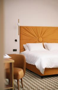 罗兹Hotel Pietryna的一间卧室配有一张床、一把椅子和一张书桌