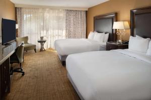 伍德森特瑞斯圣路易斯机场希尔顿酒店的酒店客房设有两张床和电视。