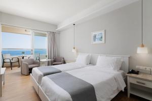 达西亚Elea Beach Hotel的酒店客房设有一张床,享有海景。