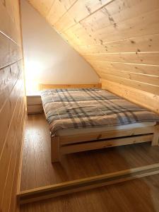 KamesznicaHighlander - drewniany dom w Beskidach的木天花板的客房内的一张床位