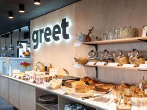 蒙特讷Greet hotel Bourg-en-Bresse Sud Montagnat的面包店在柜台上供应面包和糕点