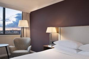 布里斯托Delta Hotels by Marriott Bristol City Centre的酒店的客房 - 带一张床、椅子和窗户
