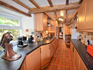 Ystrad-ffin3 Bed in Llandovery 76381的一个带木制橱柜和黑色台面的大厨房