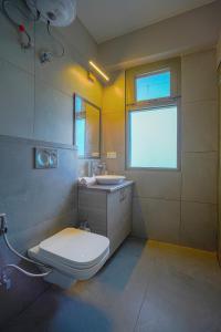 拉尼凯特SaffronStays Edelweiss Estate的一间带卫生间、水槽和窗户的浴室