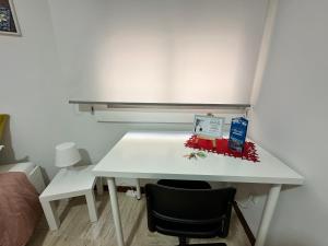 阿利坎特Moderna habitación en el corazón de Alicante的一张白色的桌子,放在带椅子的房间里