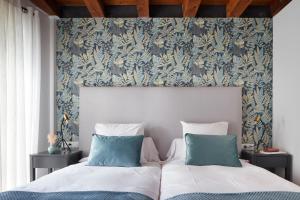 阿蒂斯Val Arties 3 by FeelFree Rentals的一间卧室配有两张带蓝白色枕头的床