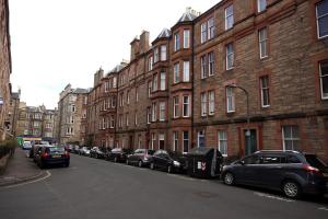 爱丁堡Hamish's Hame Edinburgh Licence No EH 69774 P的停在建筑物旁边的街道上的一排汽车