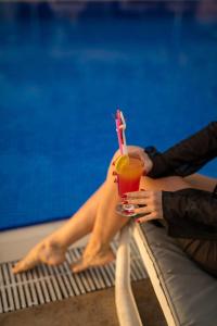 费特希耶日落海滩别墅及公寓酒店的坐在泳池里喝着饮料的人