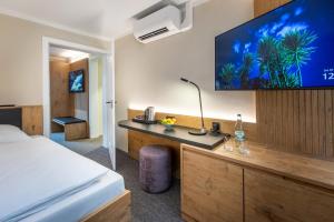 爱尔福特NASHI Rooms的配有一张床和一台平面电视的酒店客房