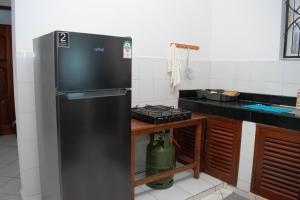 姆特瓦帕皇家棕榈瓦帕公寓的厨房配有黑色冰箱和炉灶。