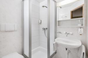 维尔德斯韦尔阿尔卑斯玫瑰酒店及花园的带淋浴和盥洗盆的白色浴室