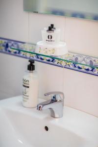 塞维利亚甜蜜的梦酒店的浴室水槽和一瓶肥皂